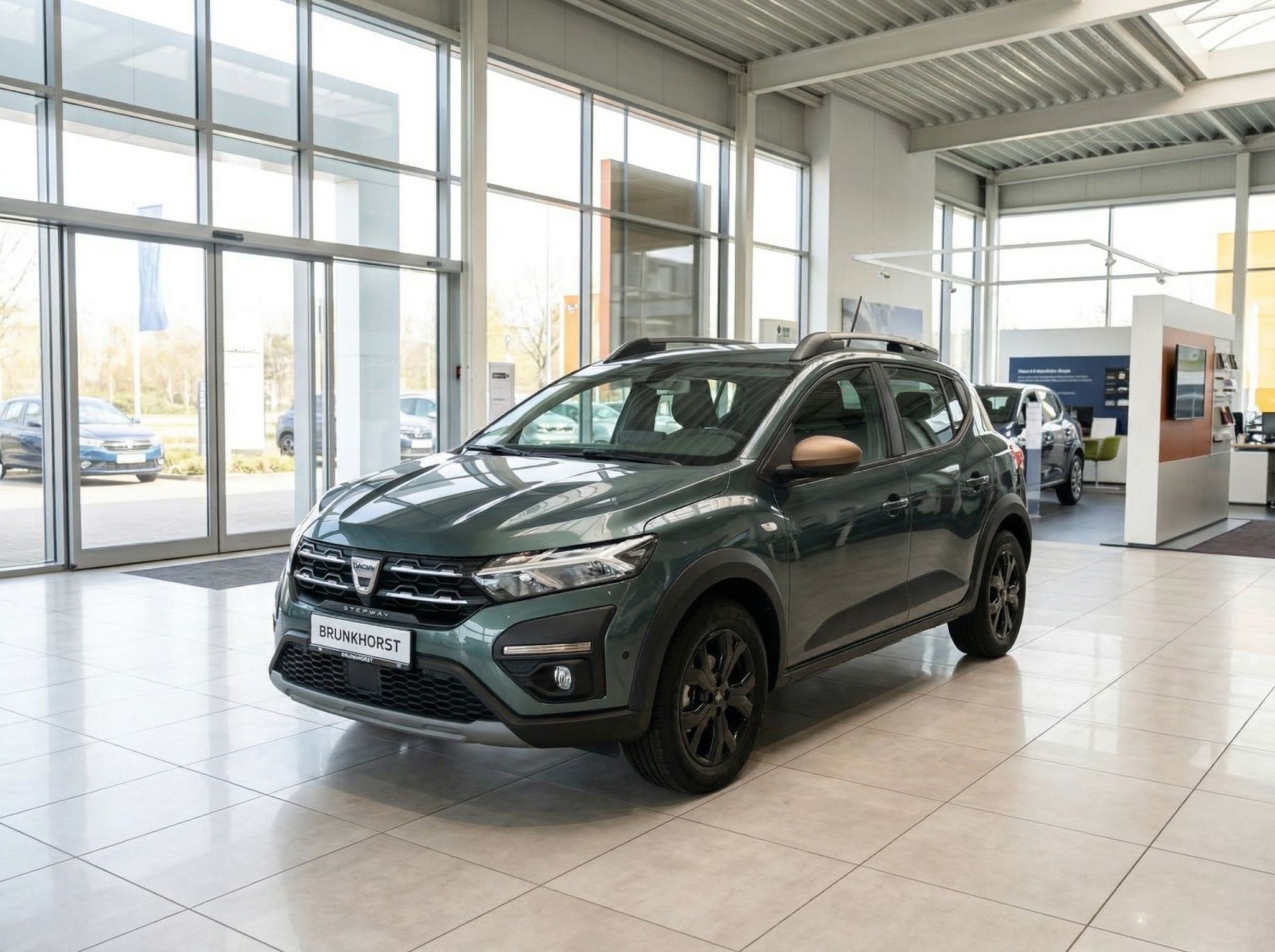Dacia Sandero grün metallic im Autohaus Showroom - Seitenansicht des Kompaktwagens