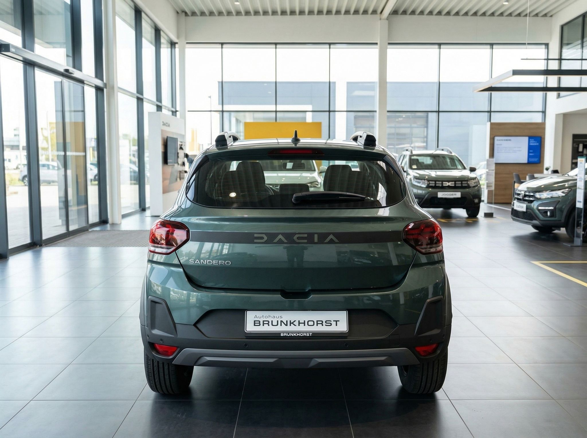 Dacia Sandero grün metallic Heckansicht im Autohaus - Rückseite des Kompaktwagens