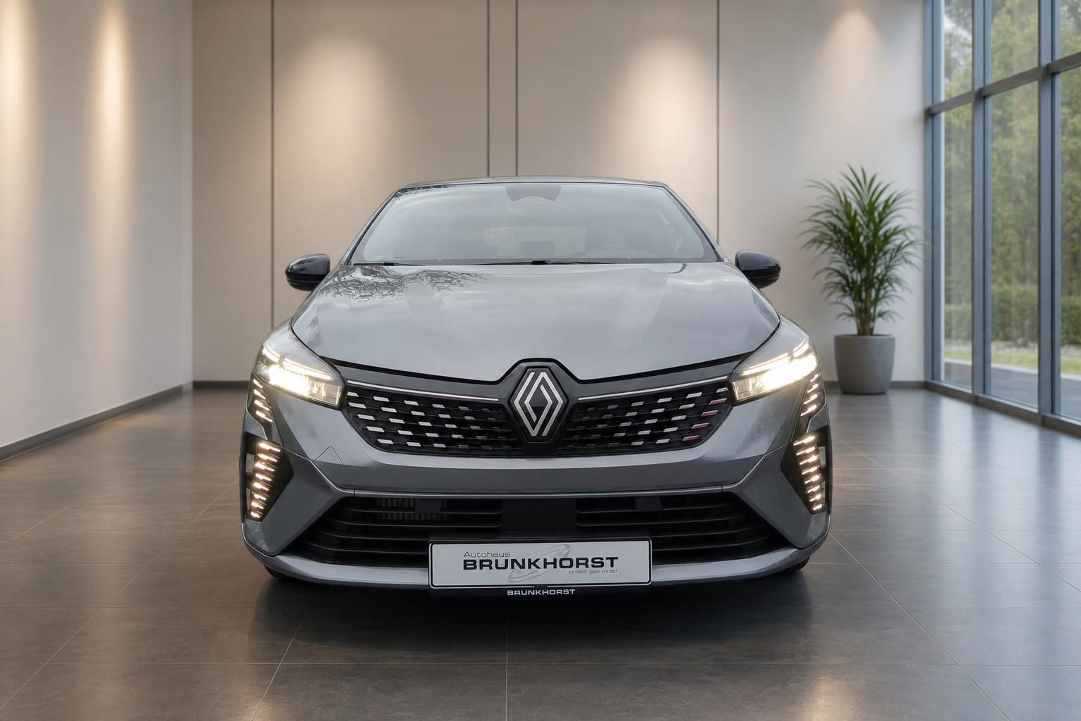 Renault Clio grau Frontansicht mit markanten LED-Tagfahrlichtern im modernen Autohaus