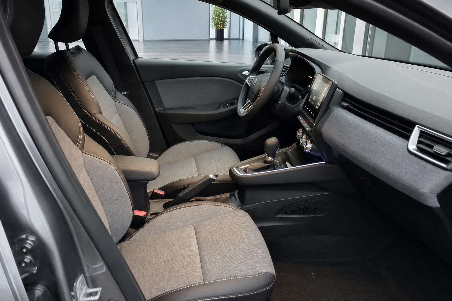 Renault Auto Innenraum mit beigen Stoffsitzen, Schaltknauf und modernem Dashboard in grau