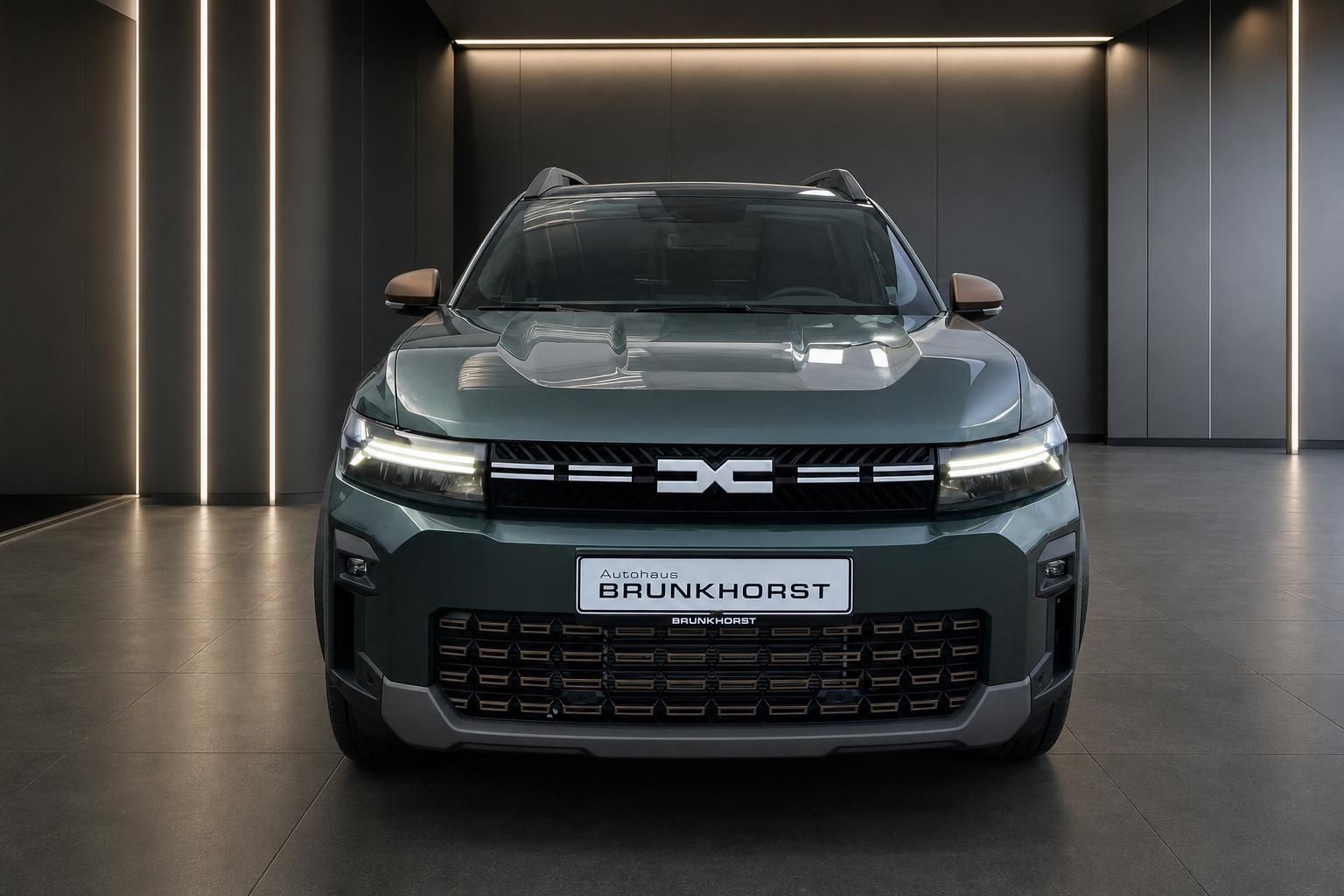Dacia SUV Frontansicht in grau-grün mit markanter Kühlergrill-Optik im Autohaus