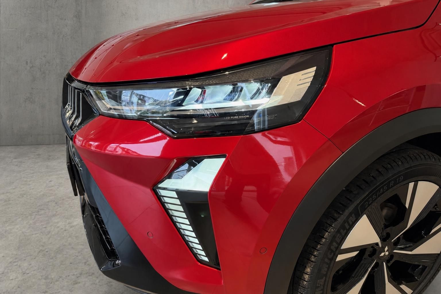 Nahaufnahme LED-Scheinwerfer und Felge eines roten SUV-Fahrzeugs
