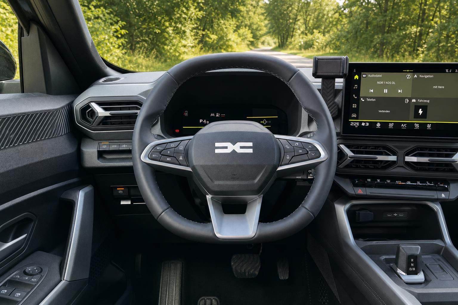 Cockpit-Ansicht mit Lenkrad, Instrumententafel und Infotainment-Display im Fahrzeuginneren