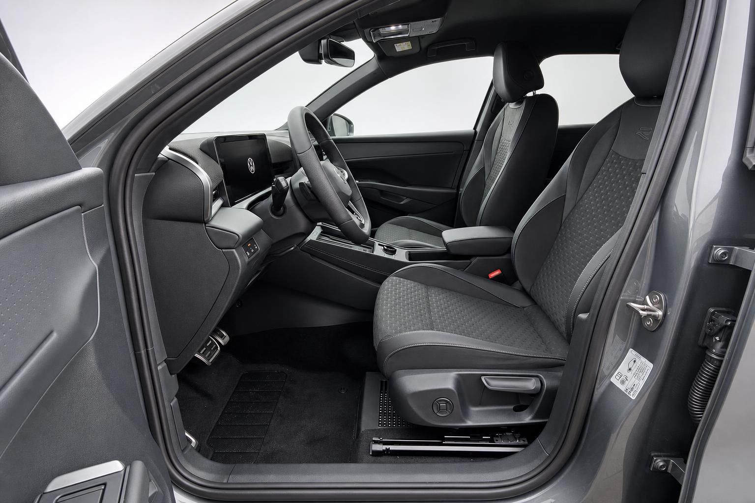 Fahrersitz und Cockpit im VW Innenraum, Ansicht durch offene Tuer