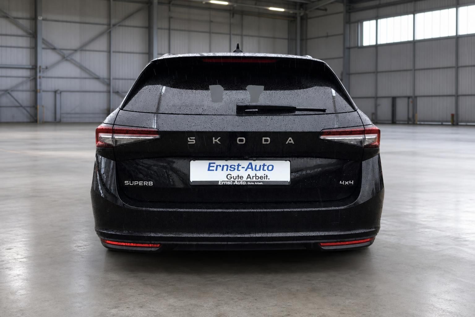 Skoda Superb 4x4 in schwarz - Heckansicht mit Ernst-Auto Kennzeichen in Lagerhalle