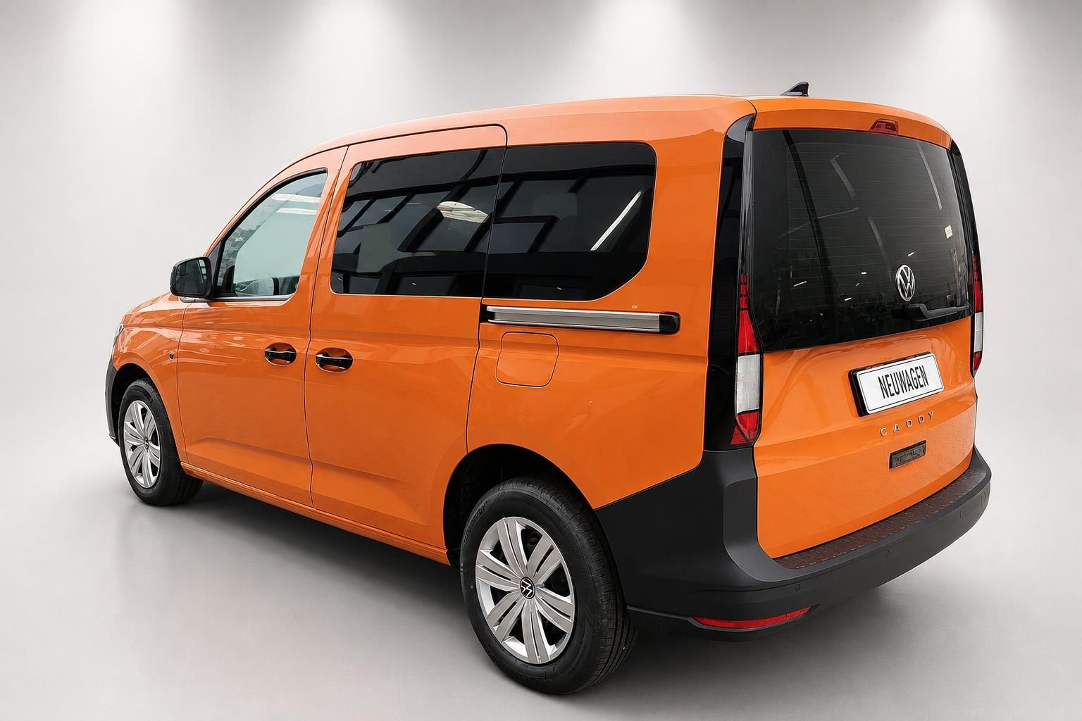 VW Caddy orange, Heckansicht schraeg mit Kennzeichen