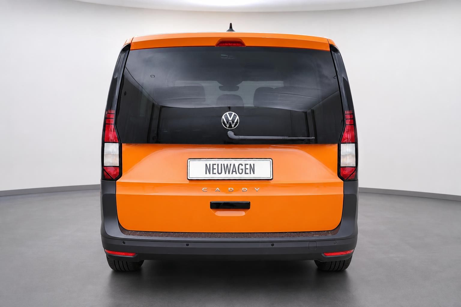 VW Caddy in Orange, Heckansicht im Studio