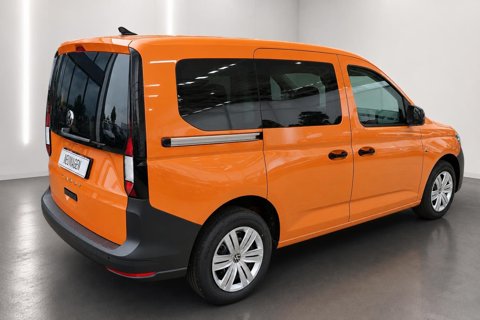 VW Caddy Orange, Heck- und Seitenansicht schraeg