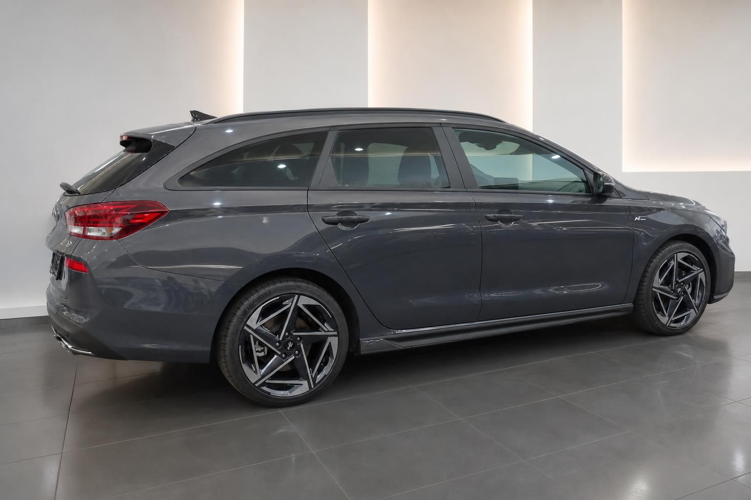 Grauer Hyundai Kombi Seitenansicht mit Sportfelgen in modernem Showroom