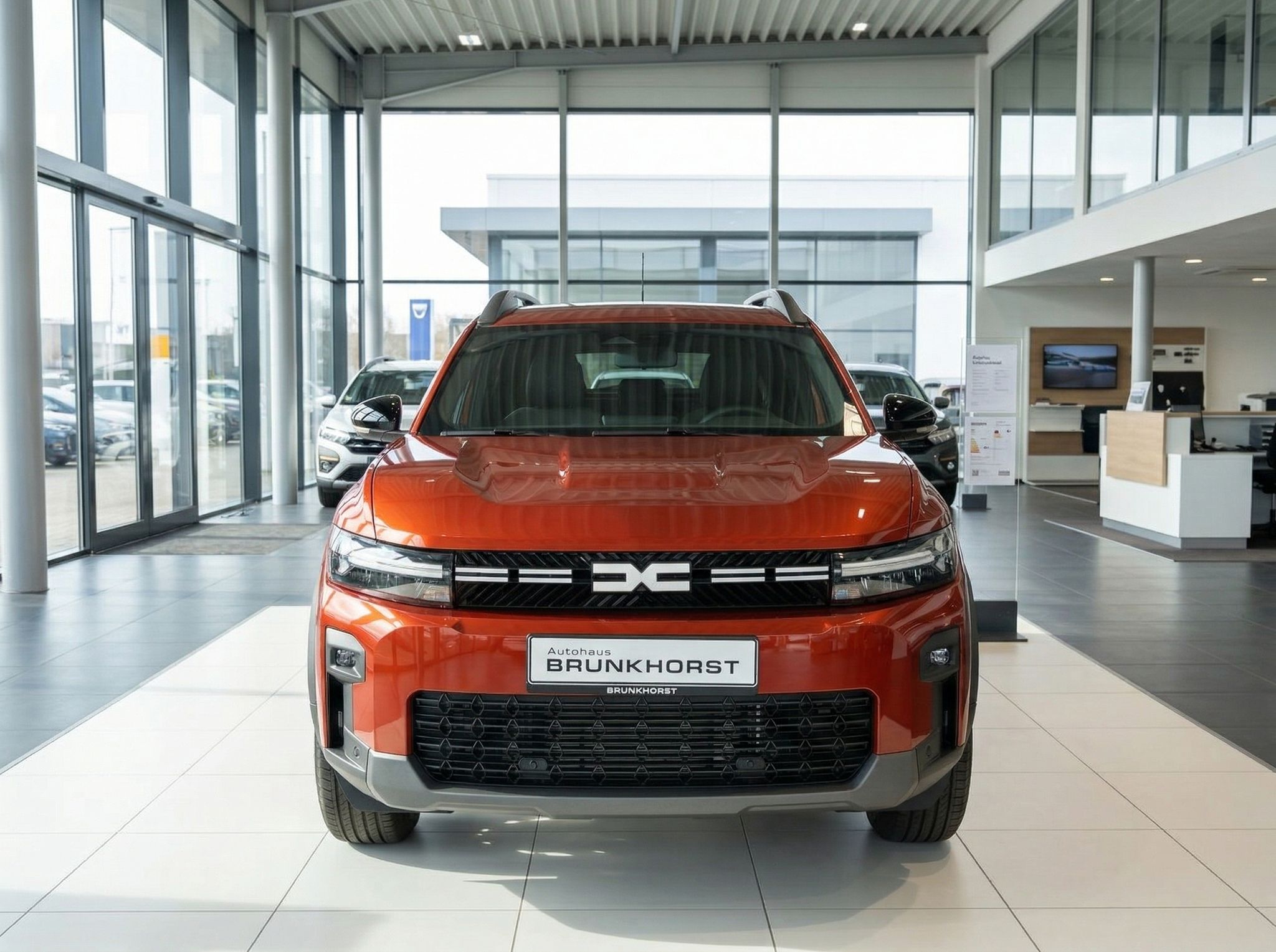 Roter Dacia Bigster SUV Frontansicht im Autohaus Showroom - markante Kühlergrill-Optik und DC-Logo