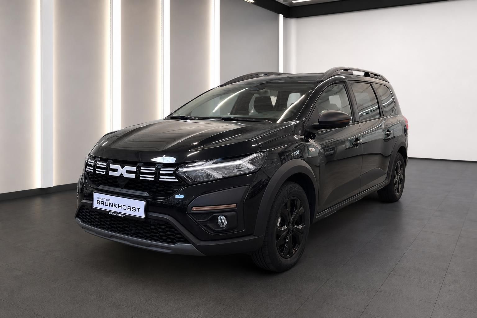 Schwarzer Dacia SUV in moderner Ausstellung - Frontansicht mit markanter Kühlergrill