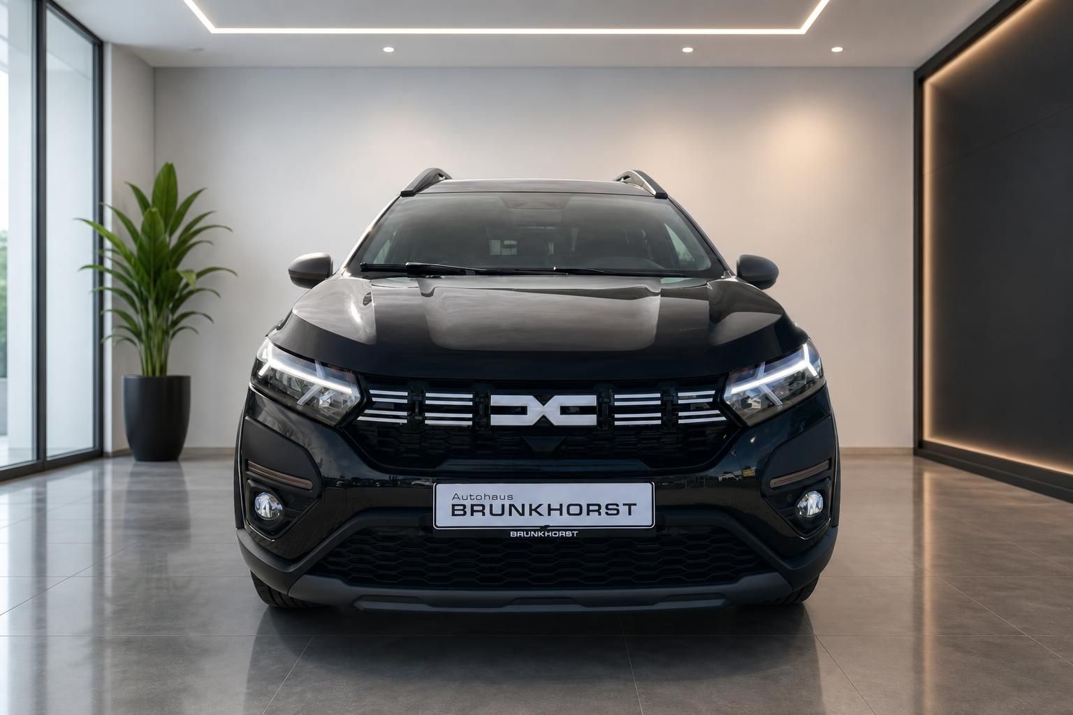 Dacia SUV Frontansicht in Schwarz im modernen Autohaus Showroom mit LED-Scheinwerfern