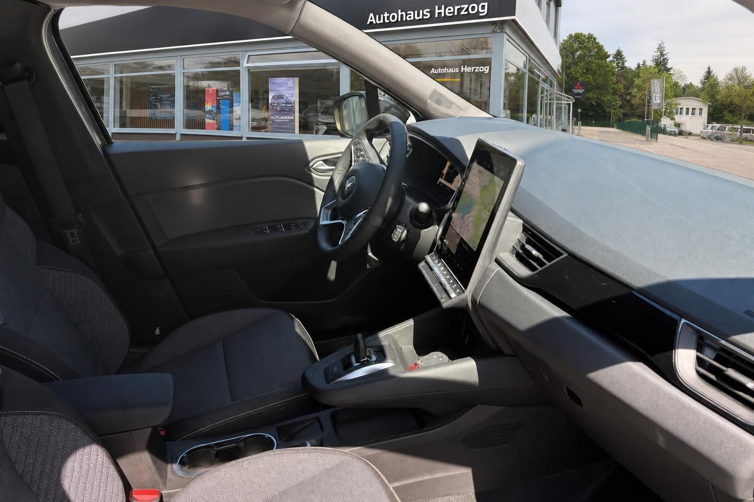 Mitsubishi Innenraum Fahrerseite mit Lenkrad, Sitzen und großem Touchscreen