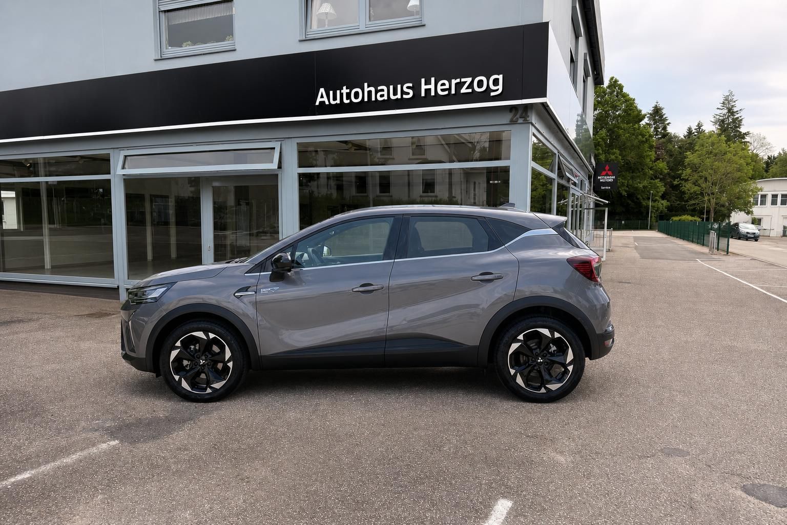 Mitsubishi ASX grau Seitenansicht links vor Autohaus Herzog – Kompakt-SUV Neufahrzeug