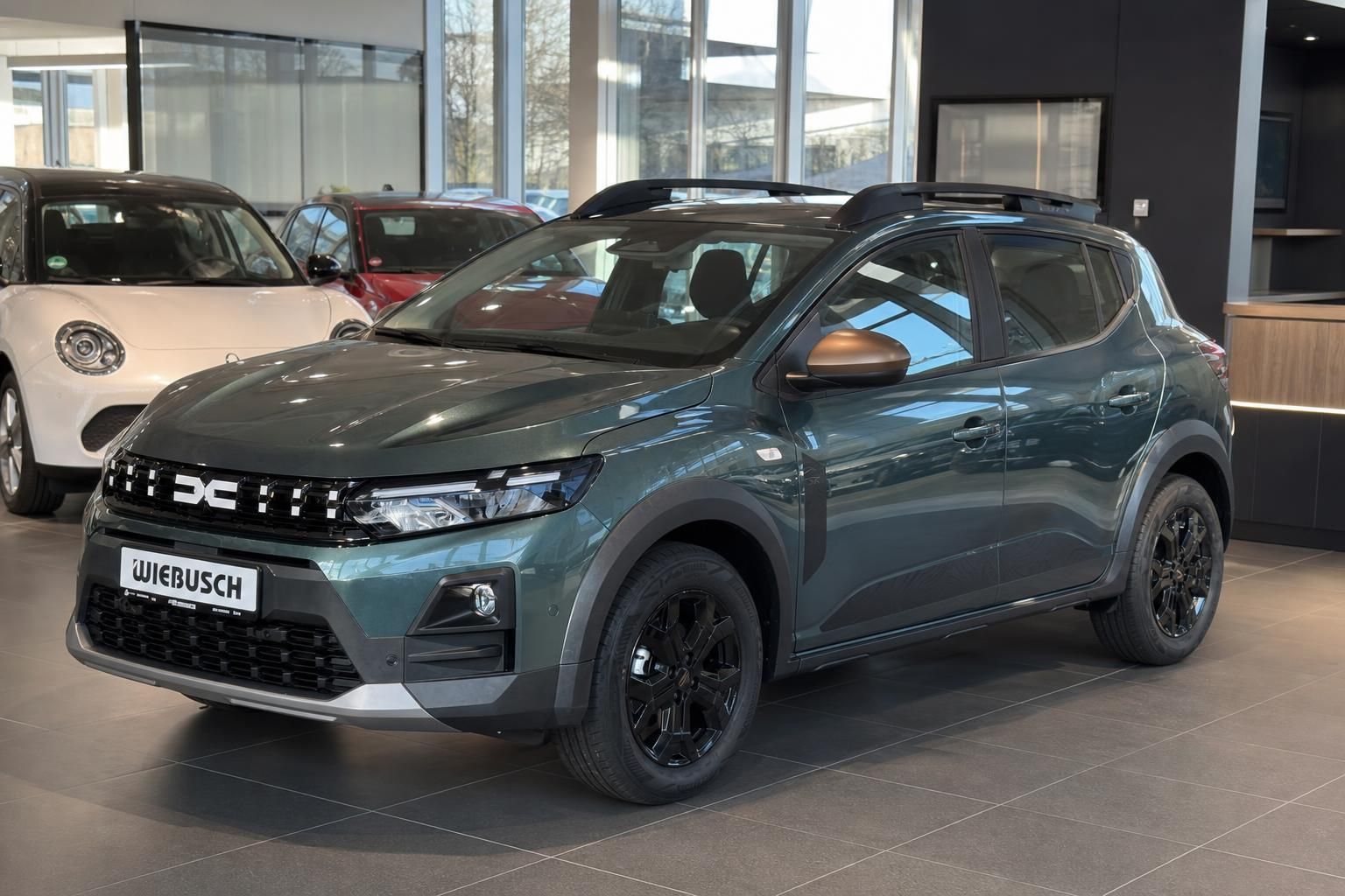 Grüner Dacia Sandero Stepway Schrägansicht vorne mit Wiebusch Kennzeichen im Autohaus