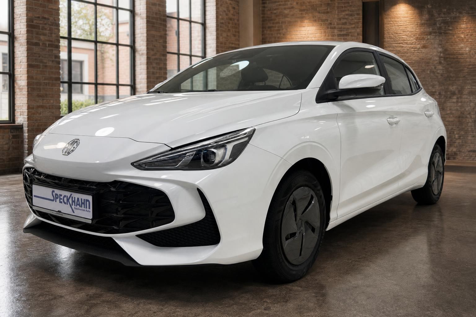 MG3 Hybrid+ weiß, Frontansicht schräg in moderner Halle mit Backsteinwand