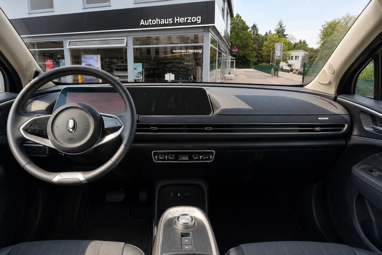 Cockpit-Ansicht mit Lenkrad und Armaturenbrett vor Autohaus Herzog