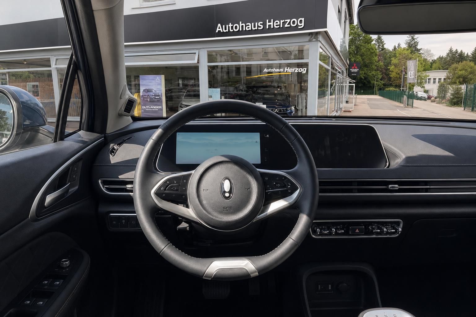 Fahrzeuginnenraum mit Lenkrad und Digitaldisplay beim Autohaus Herzog