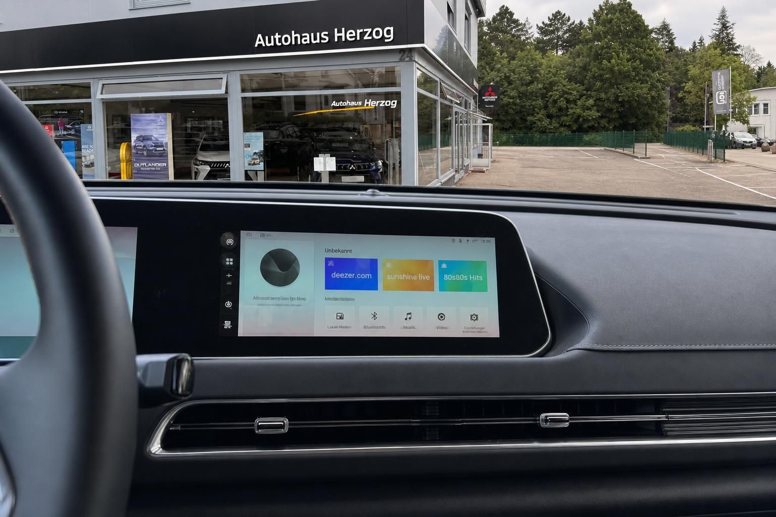 Multimedia-Display mit Musik-Apps im Fahrzeug vor Autohaus Herzog