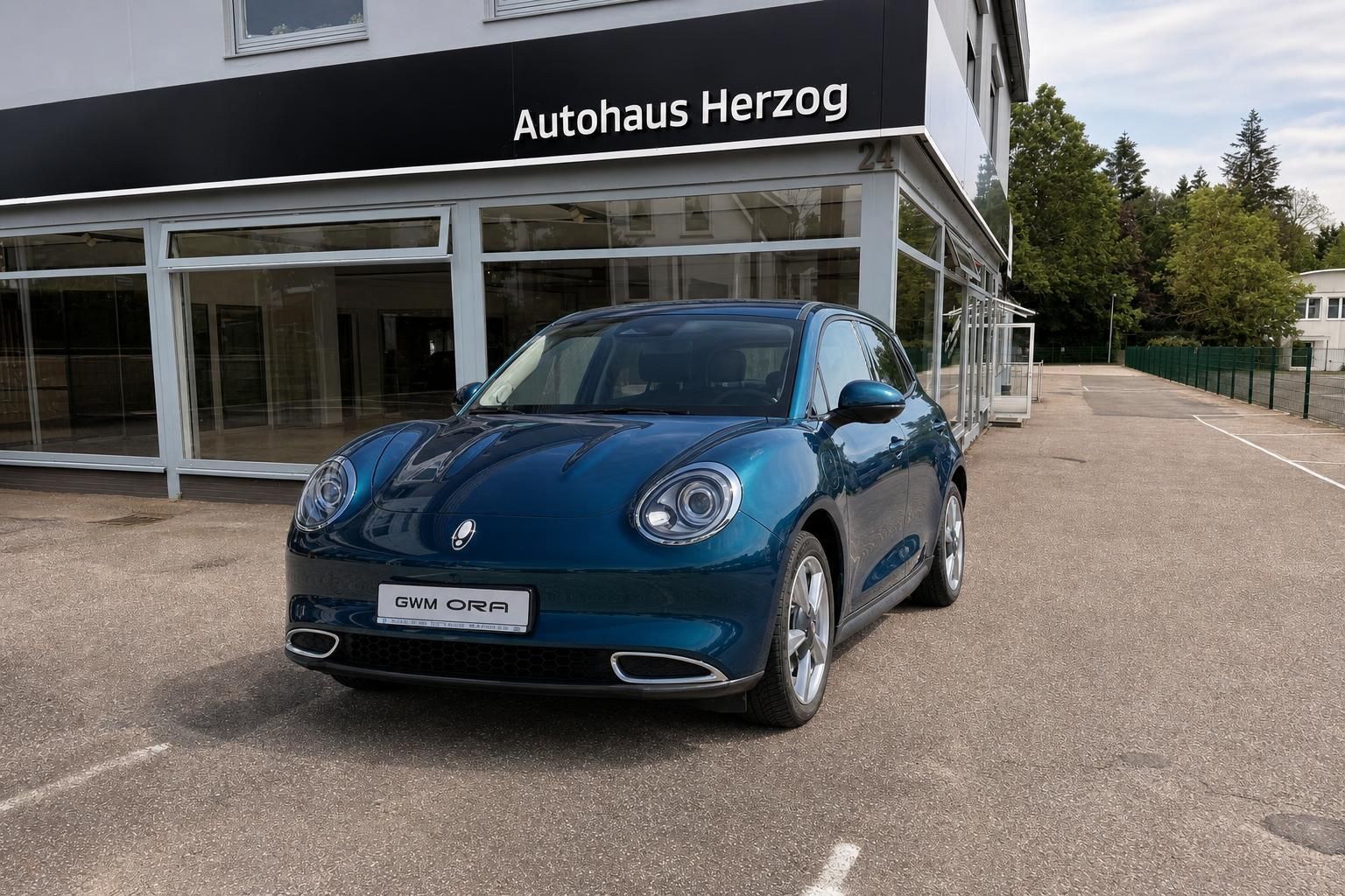 GWM Ora blau metallic, Frontansicht vor Autohaus Herzog