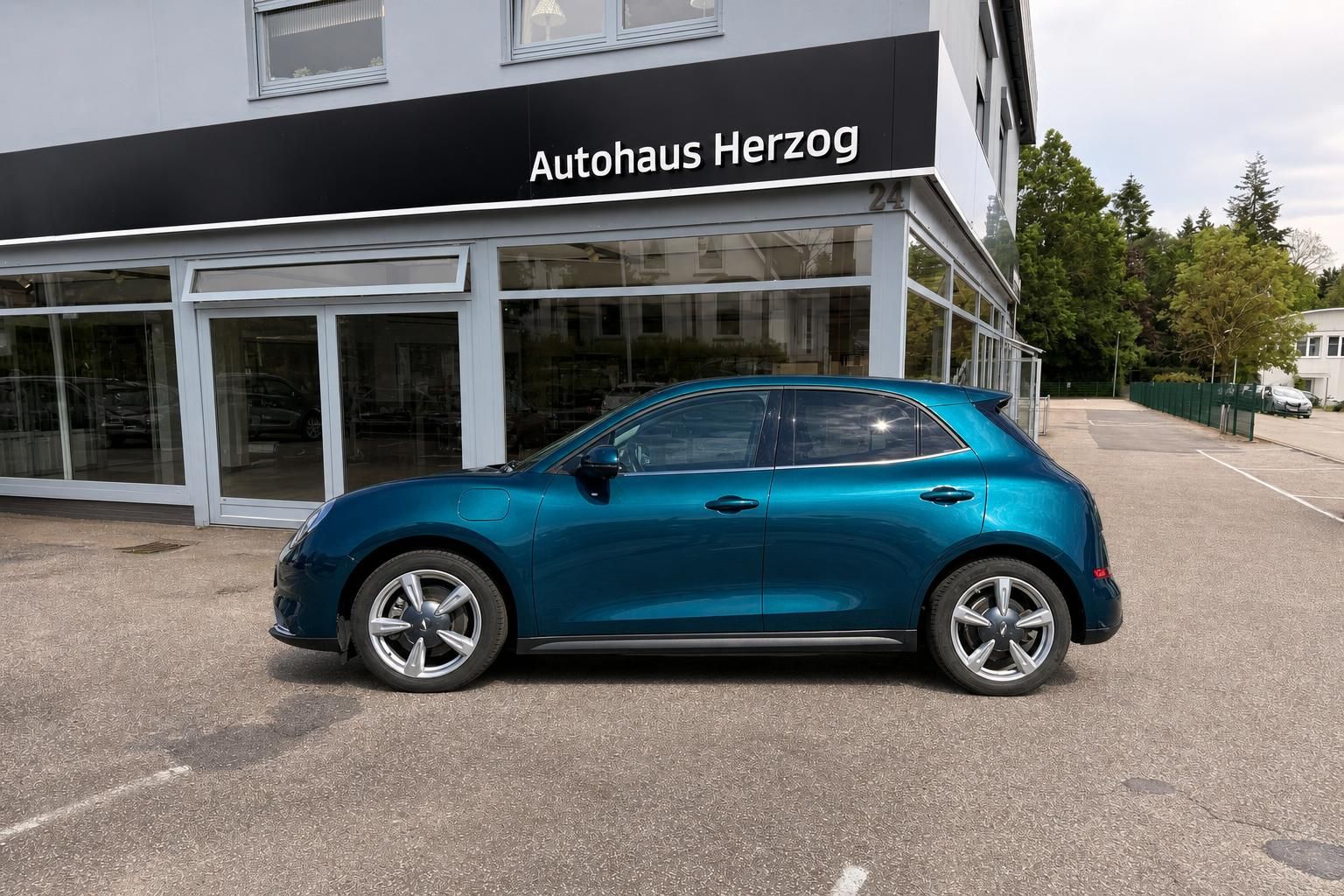 GWM Ora blau metallic, Seitenansicht auf Hofplatz