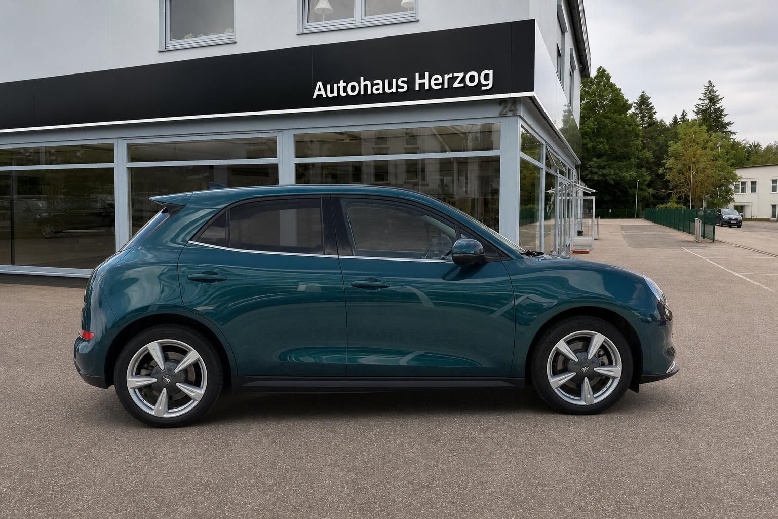 GWM Ora grün metallic Seitenansicht vor Autohaus Herzog