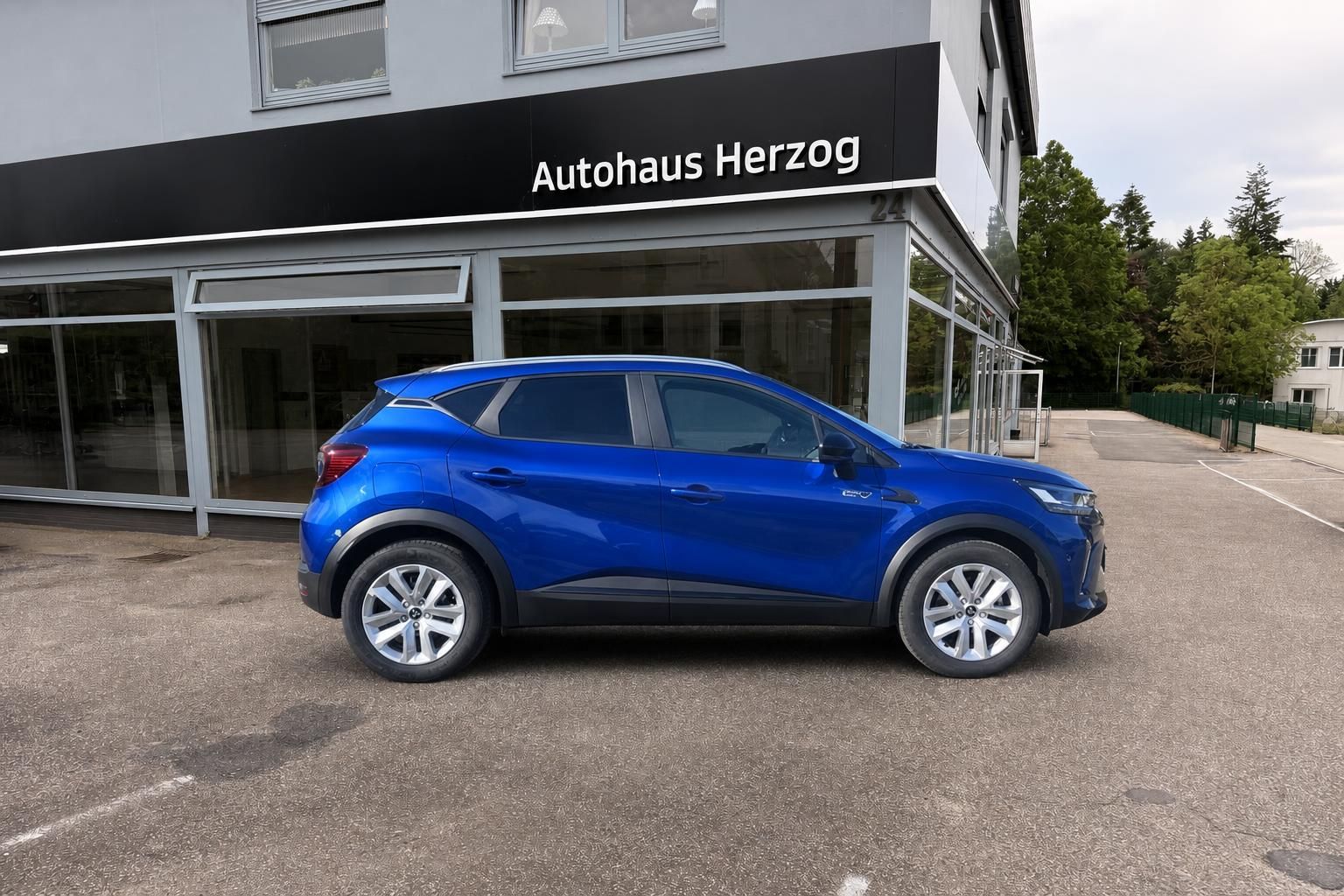 Blauer Mitsubishi ASX SUV Seitenansicht mit Alufelgen vor Autohaus Herzog Gebäude