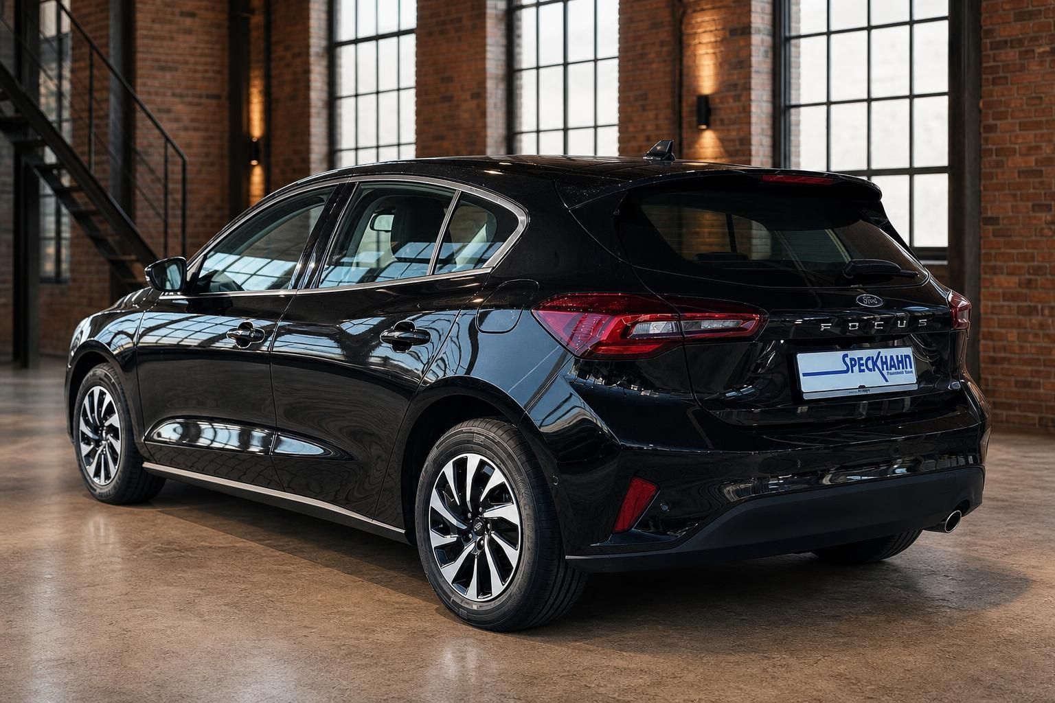 Ford Focus schwarz Heck seitlich mit Alufelgen vor Backsteinwand