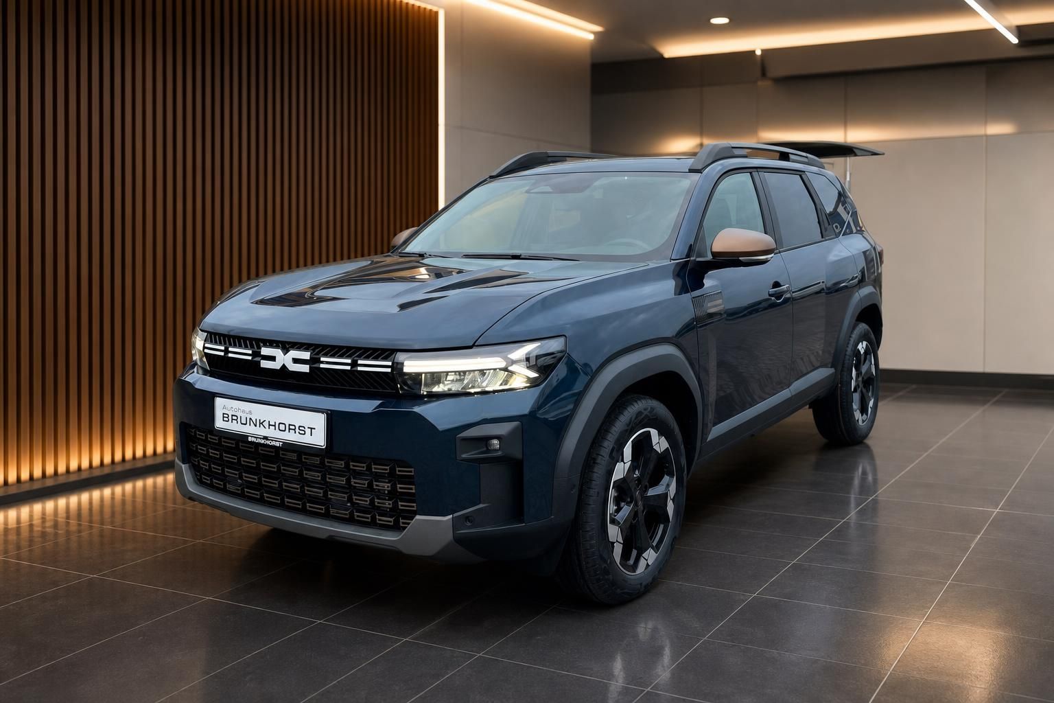 Dacia Bigster SUV Seitenansicht in blau mit schwarzen Felgen im Showroom