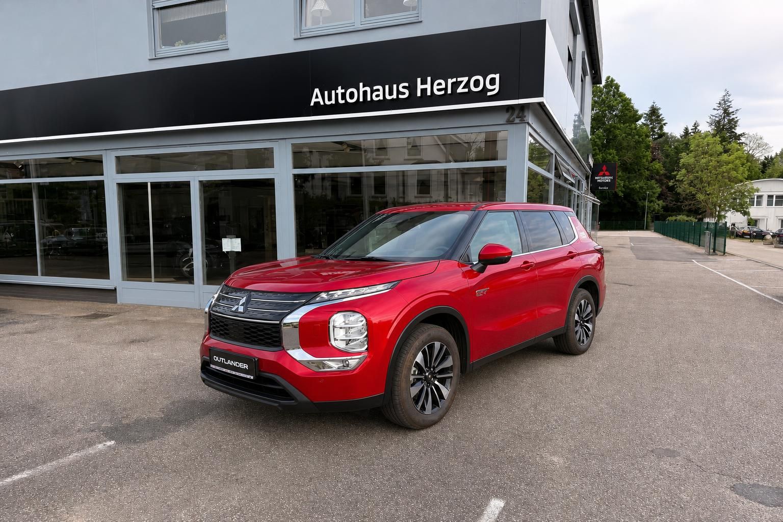 Mitsubishi Outlander rot, Frontansicht vor Autohaus Herzog