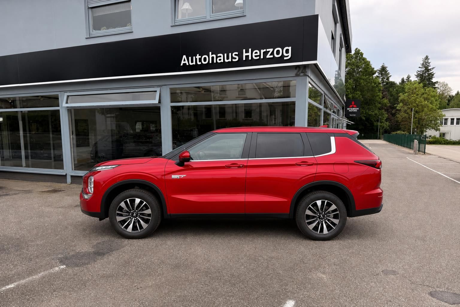 Mitsubishi Outlander rot, Seitenansicht vor Autohaus Herzog