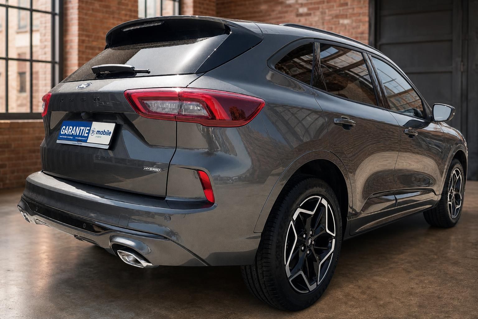 Ford Kuga Hybrid grau Heckansicht seitlich im Loft