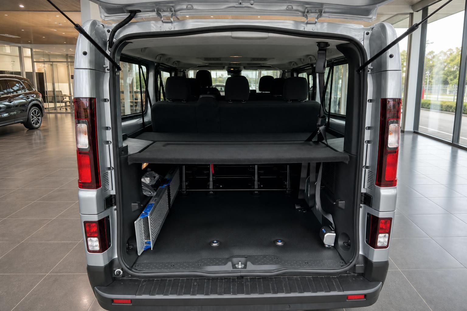 Kofferraum eines silbernen Transporters mit umklappbaren Sitzen und Staufächern