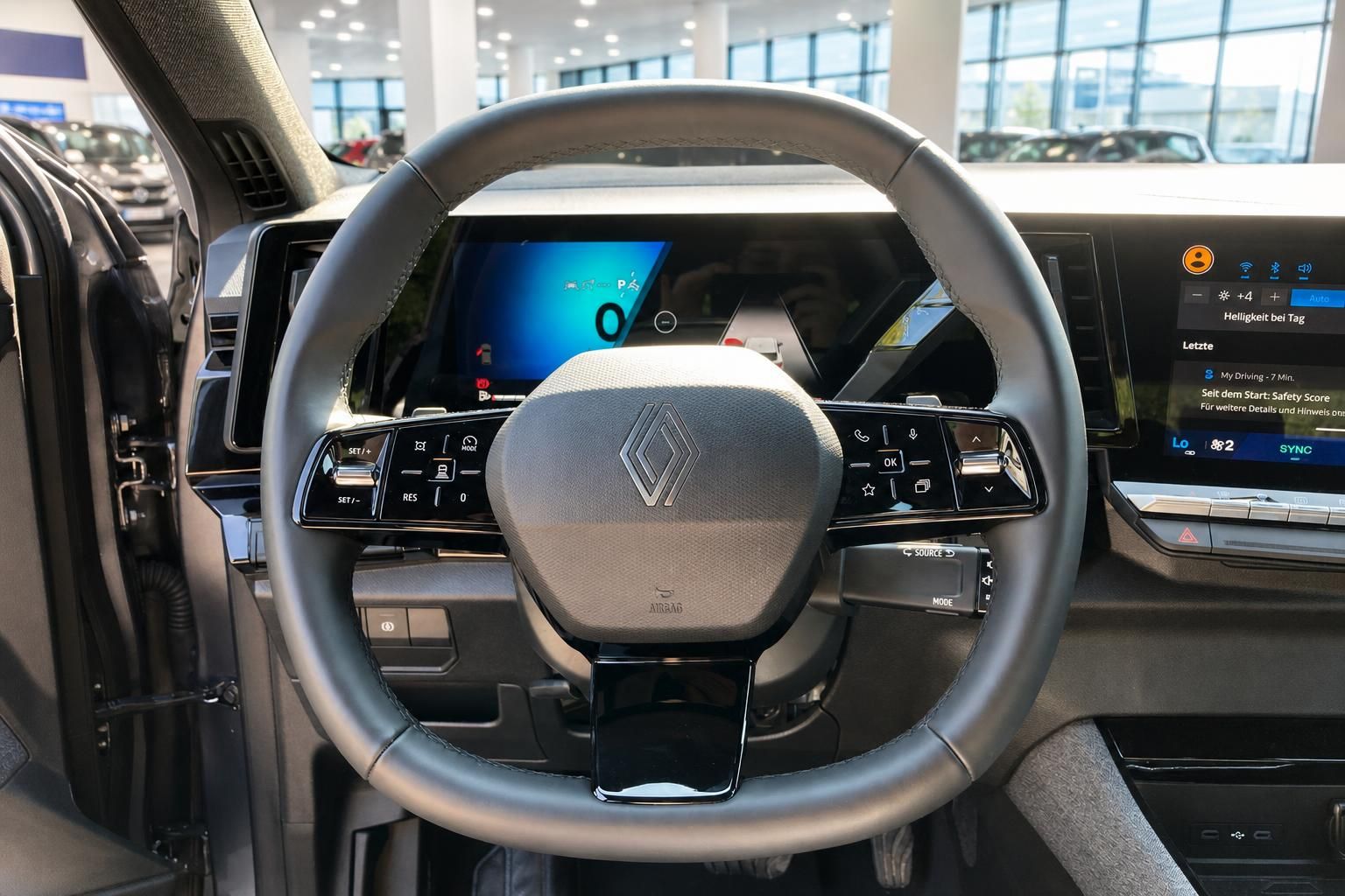 Lenkrad mit Renault-Logo und Bedienelementen im Fahrzeuginnenraum