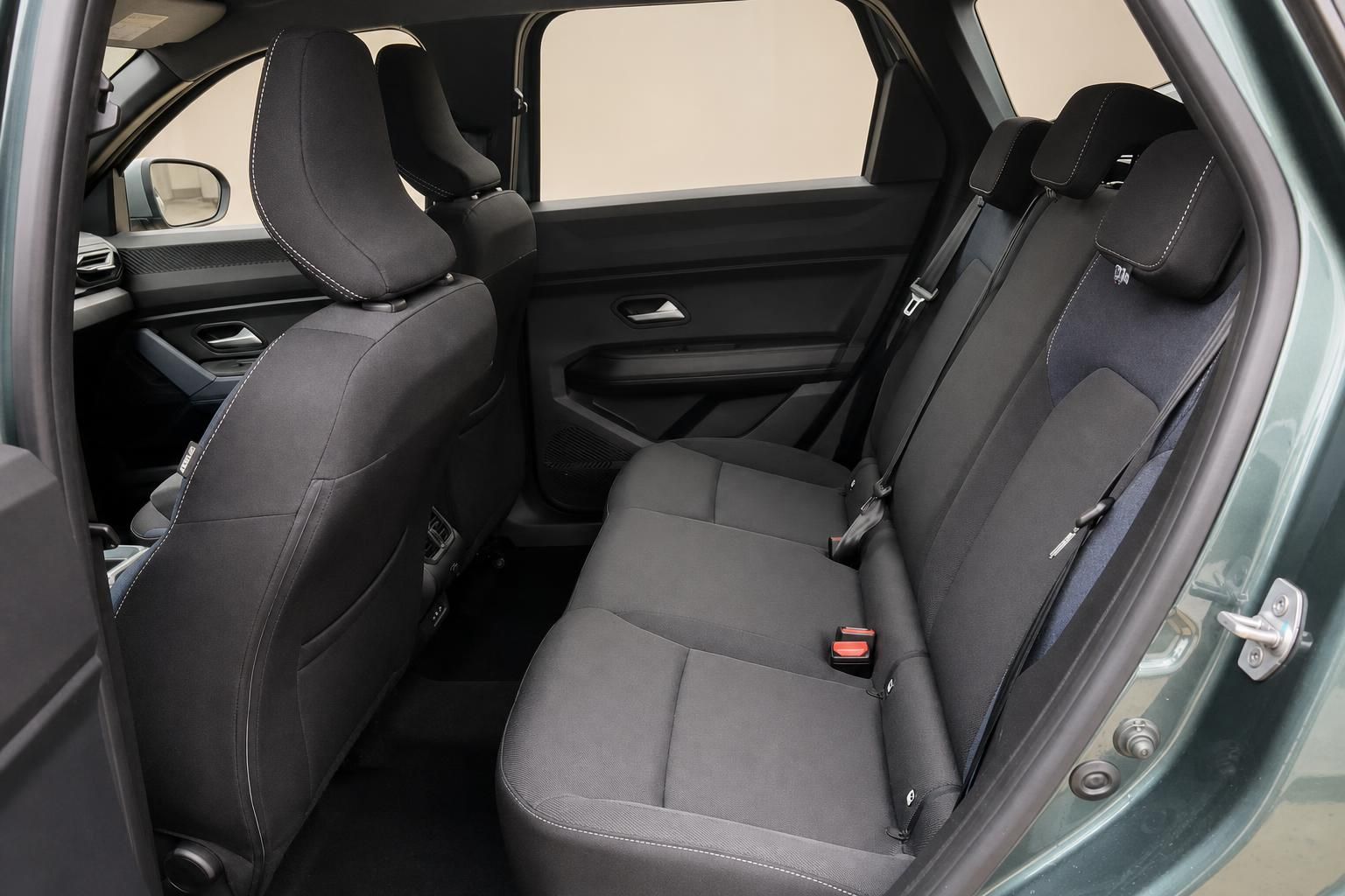 Dacia SUV Rücksitzbank schwarz mit Sicherheitsgurten und Türverkleidung grün