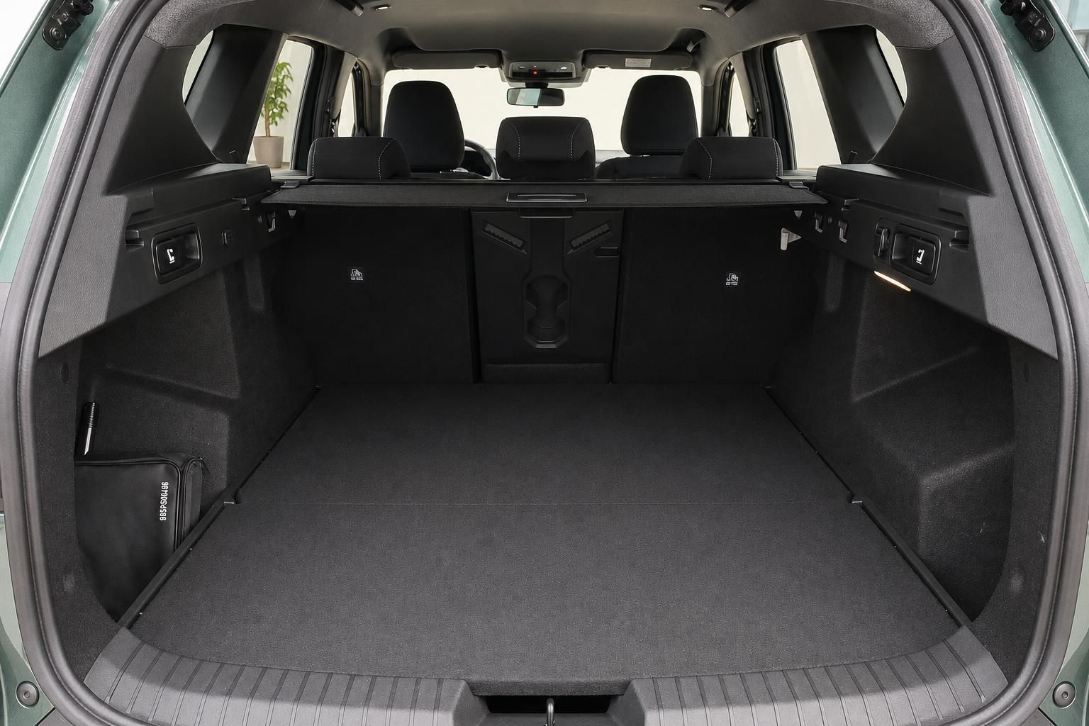Geräumiger Kofferraum eines grünen SUV mit umgeklappten Rücksitzen und schwarzer Auskleidung