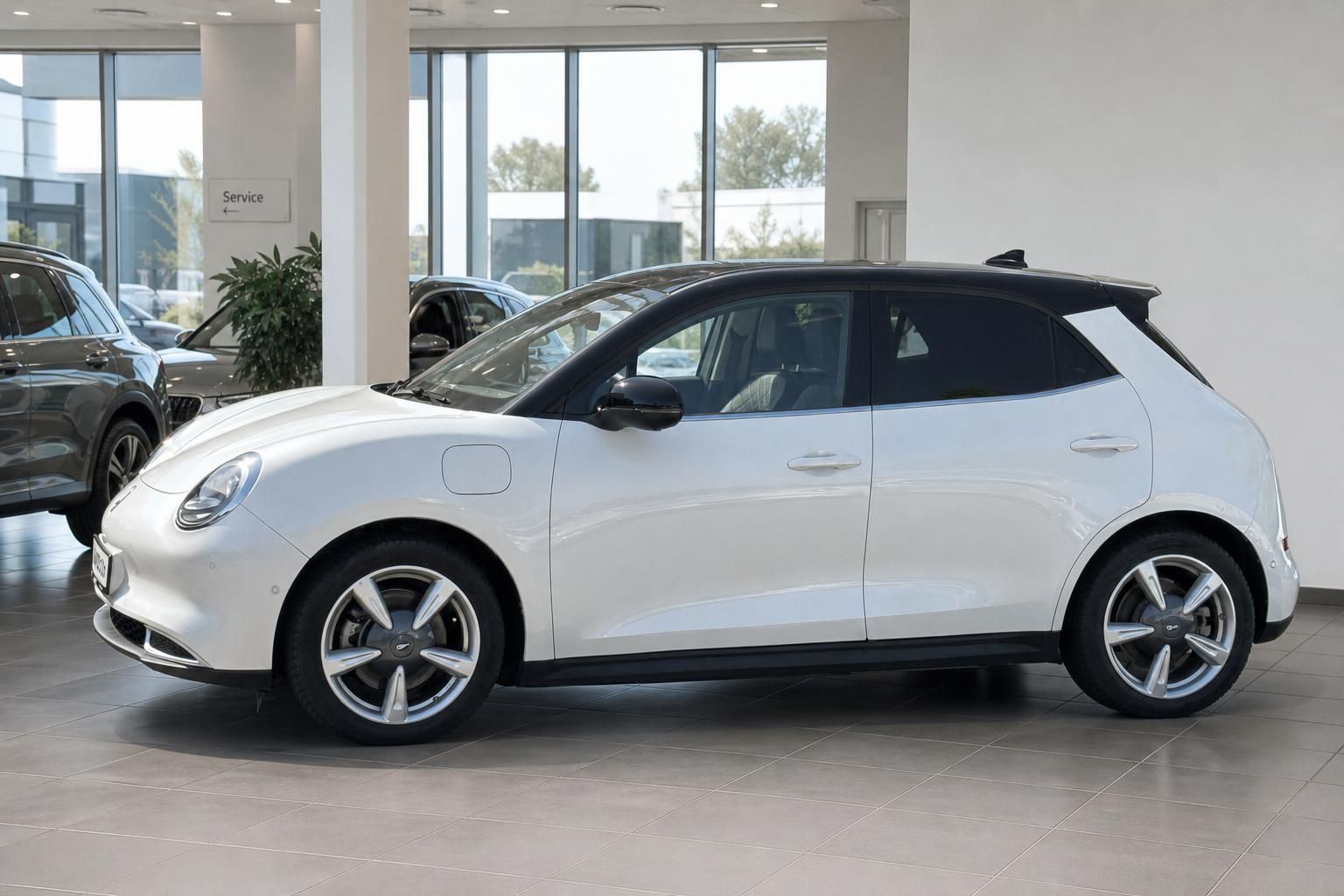 ORA Elektroauto weiß mit schwarzem Dach - Seitenprofil im modernen Showroom