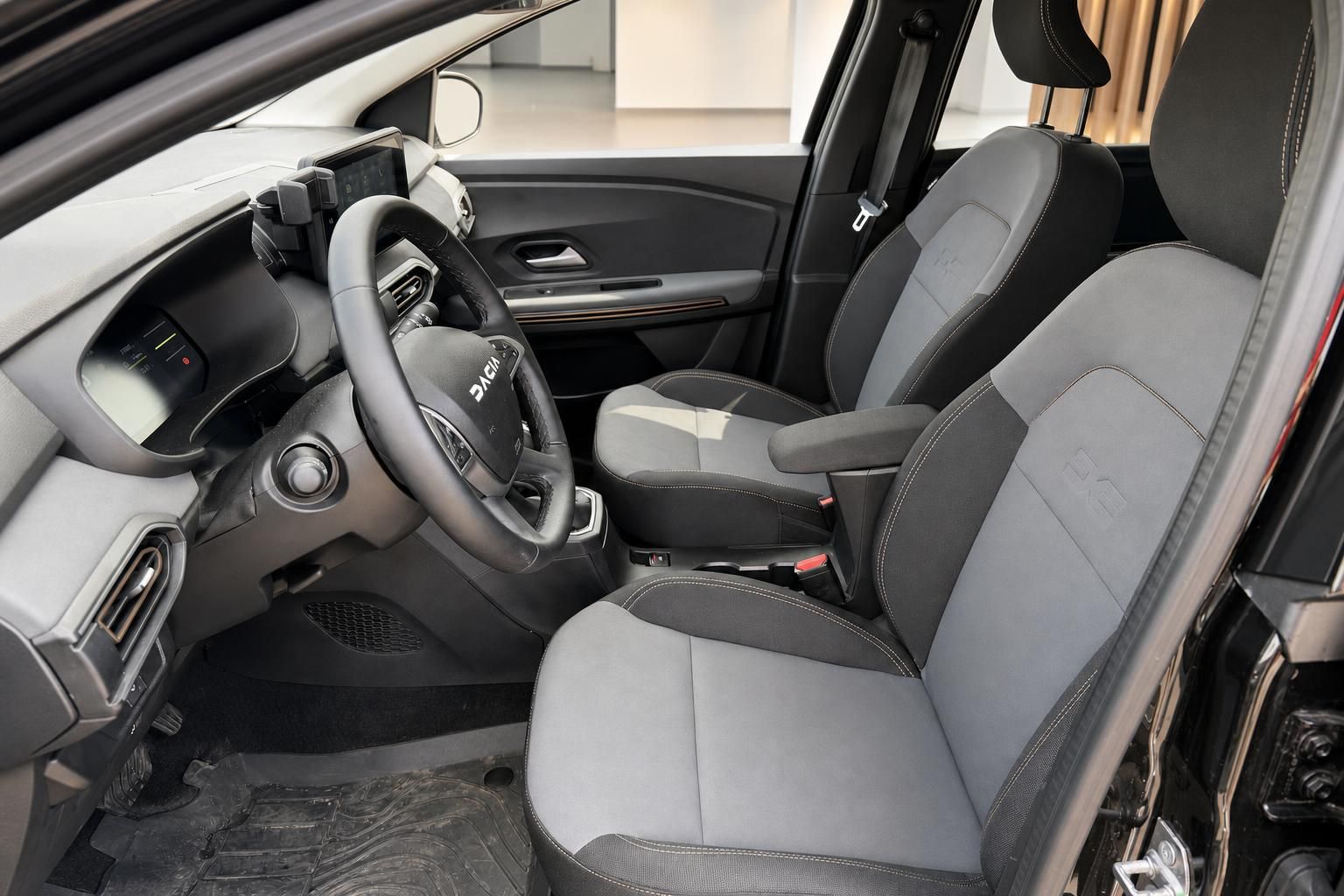 Dacia Innenraum mit Vordersitzen, Lenkrad und Cockpit in Grau-Schwarz