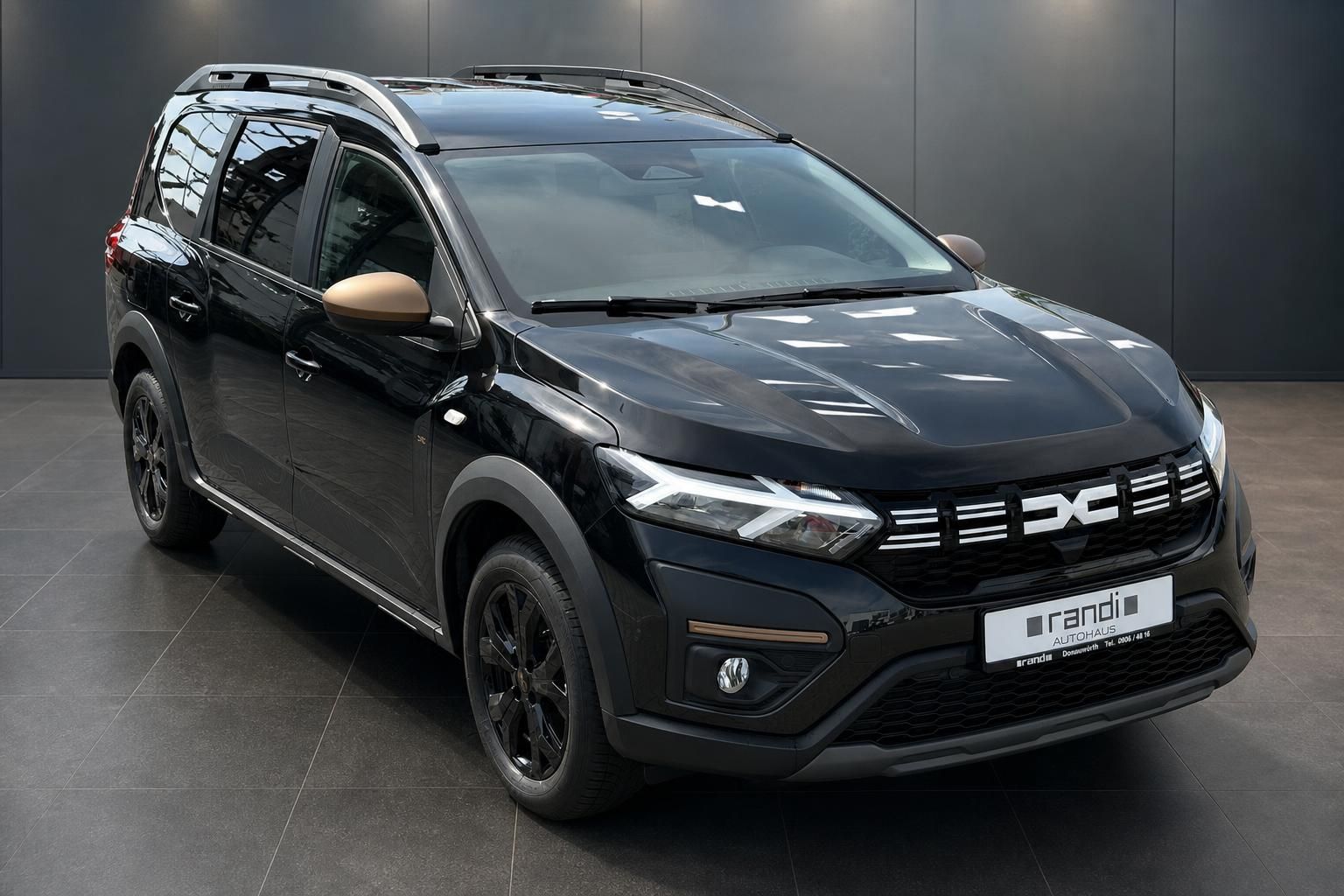 Dacia Jogger schwarz Vorderansicht schraeg mit Dachreling im Showroom