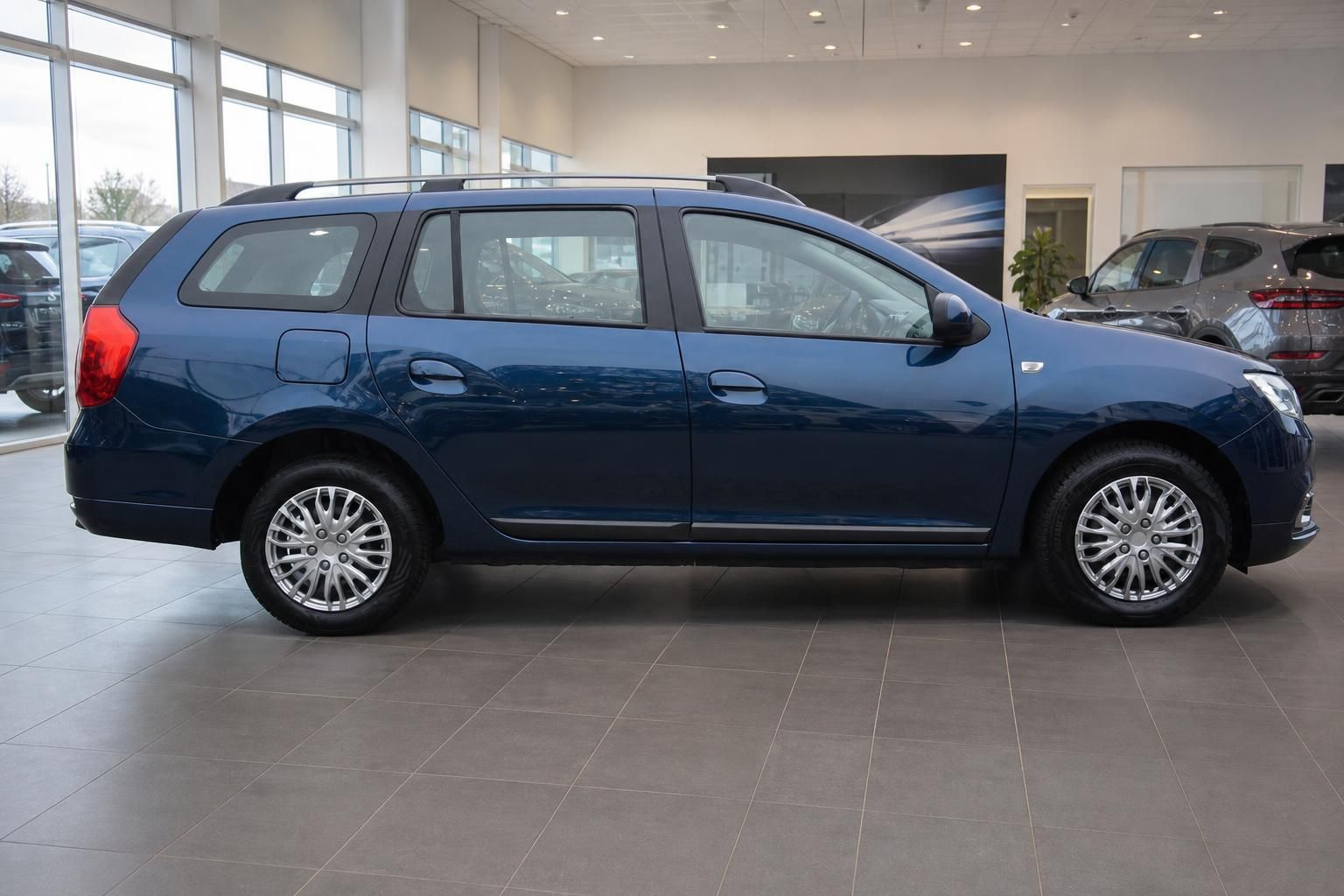 Blauer Dacia Logan MCV Kombi - rechte Fahrzeugseite mit Dachreling und Leichtmetallfelgen