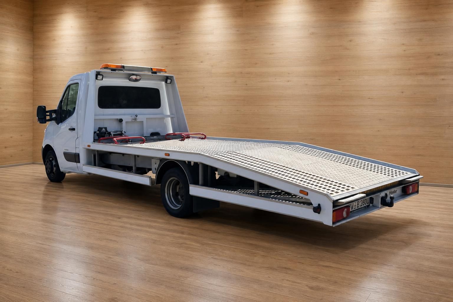 Renault Master Autotransporter weiß schräge Heckansicht mit abgesenkter Laderampe im Showroom