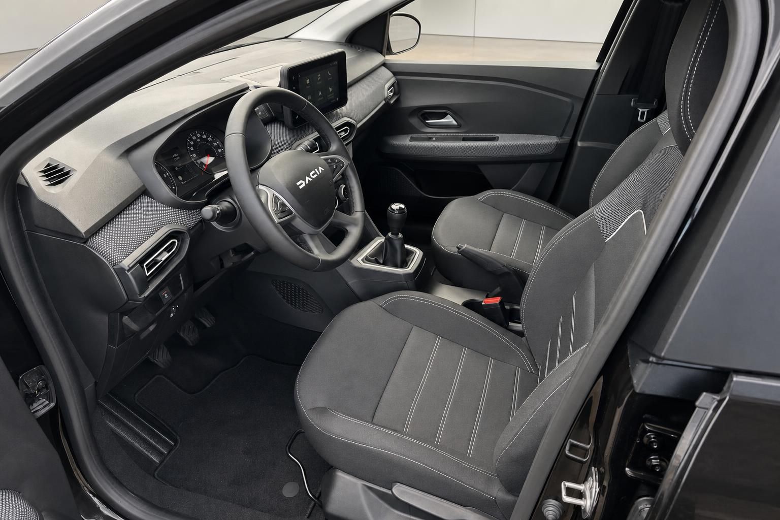 Dacia Innenraum mit schwarzen Sitzen, Lenkrad und Mittelkonsole - moderne Ausstattung sichtbar