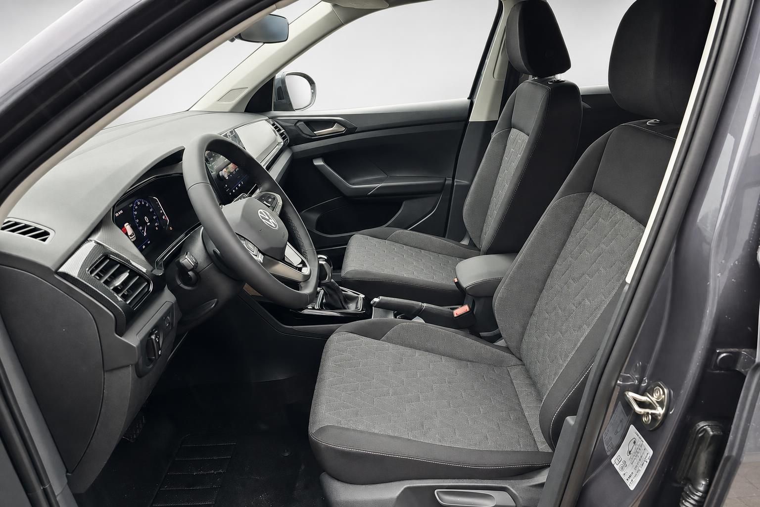 Innenraum VW T-Cross mit Stoffsitzen und Cockpit, Blick durch Fahrertuer