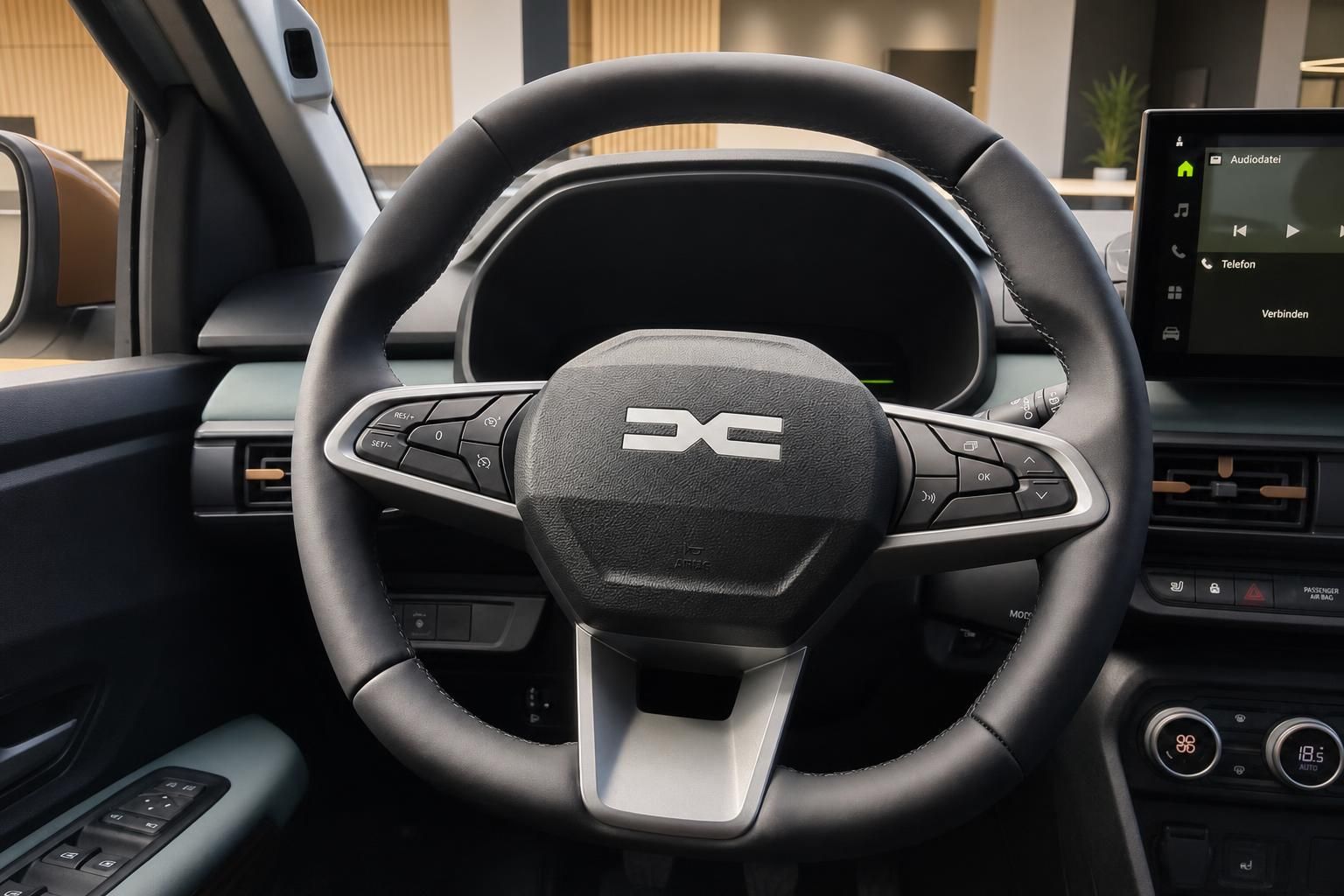 Lenkrad mit Multifunktionstasten und Infotainment-Display im Dacia Innenraum