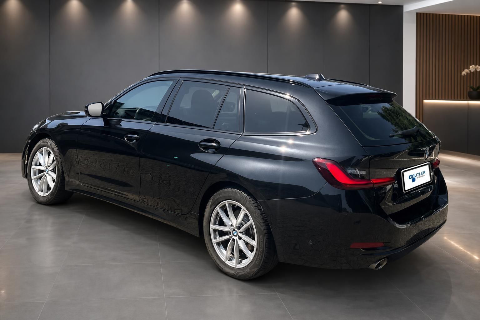 BMW 3er Touring schwarz, Seiten-Heckansicht im Showroom