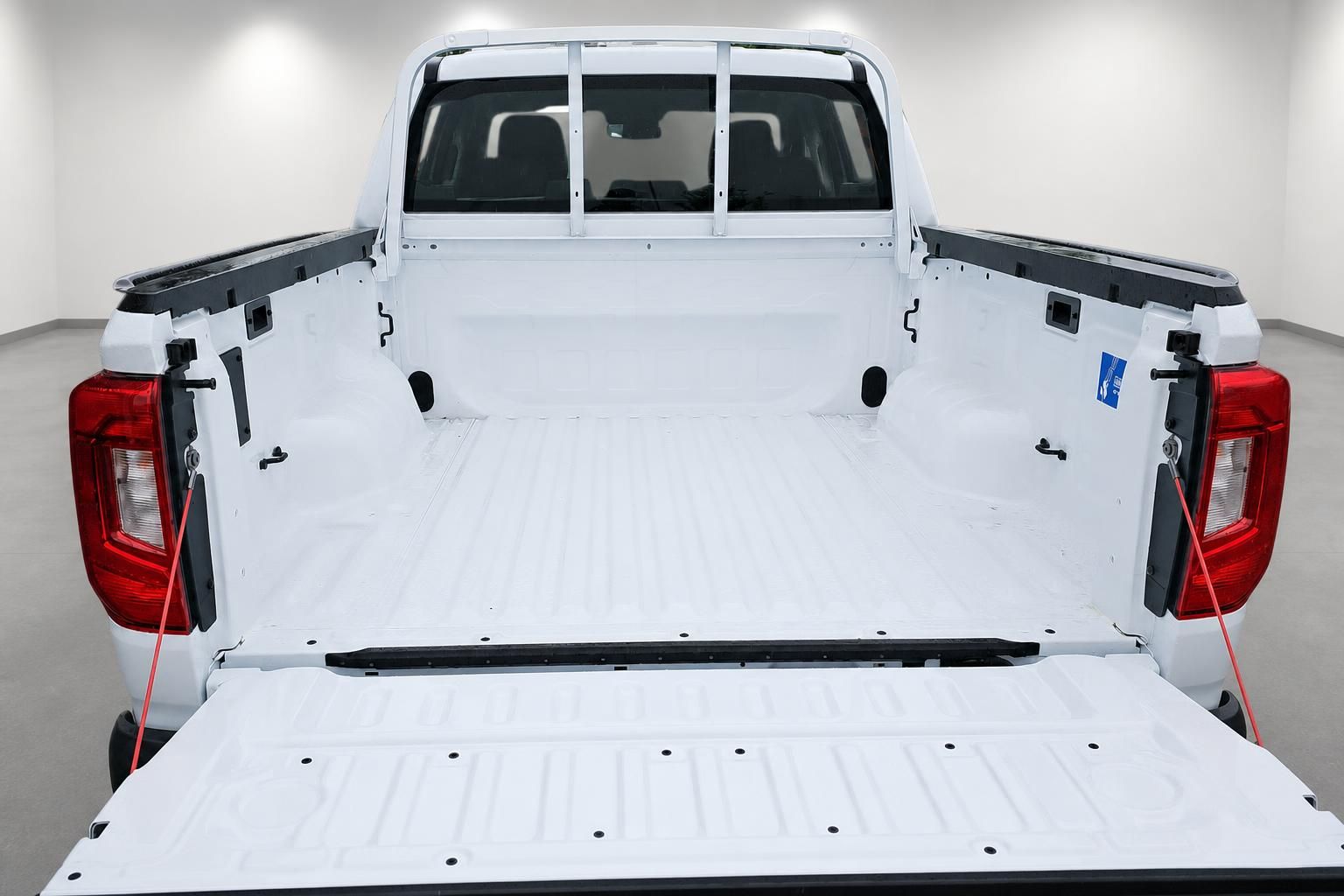 Offene Ladefläche eines weißen Pickup-Trucks von hinten