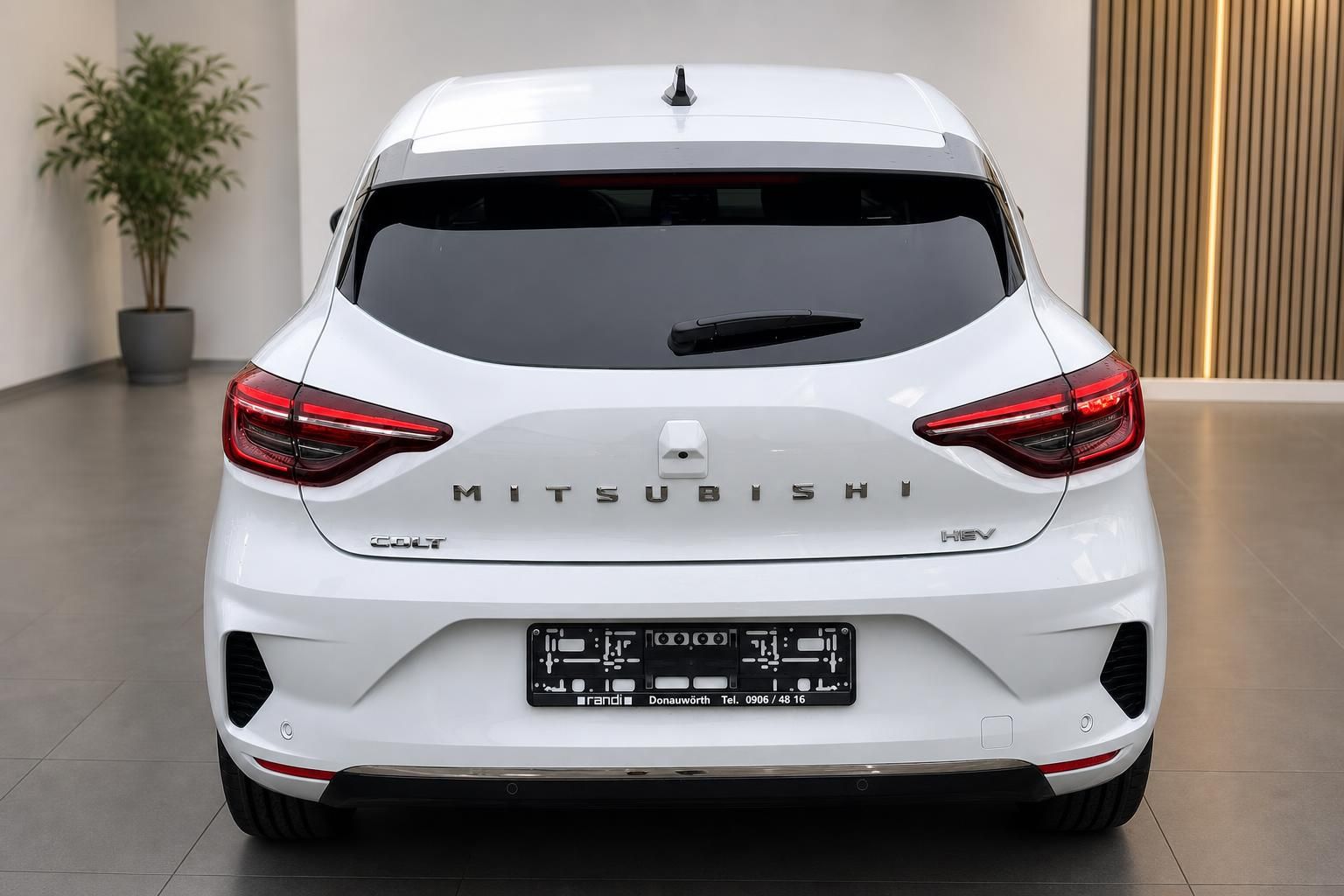 Mitsubishi Colt HEV weiss Heckansicht im Autohaus – Hybridmodell mit LED-Rueckleuchten