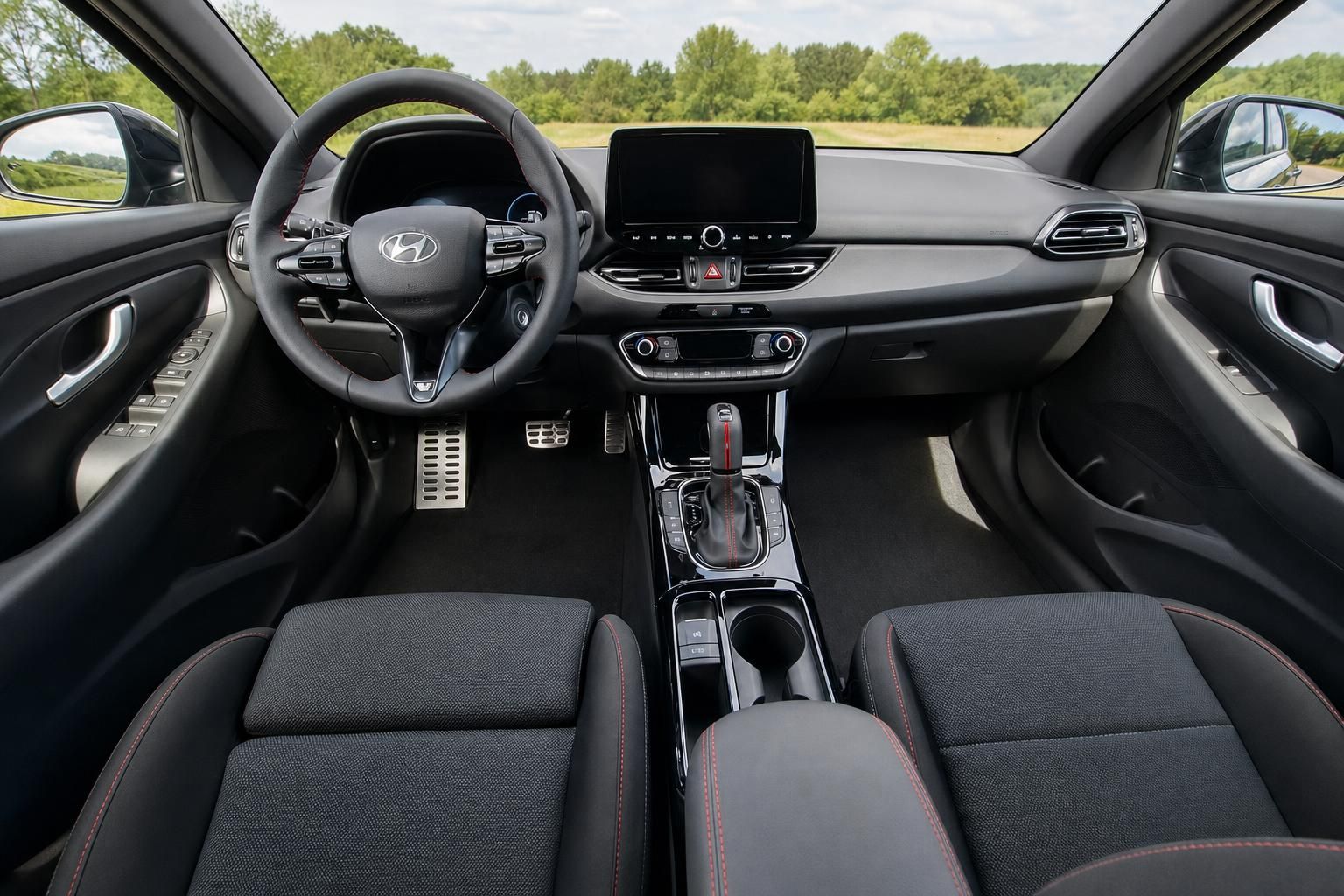 Hyundai Cockpit Übersicht mit Lenkrad, Mittelkonsole und Sportsitzen in schwarzem Interieur