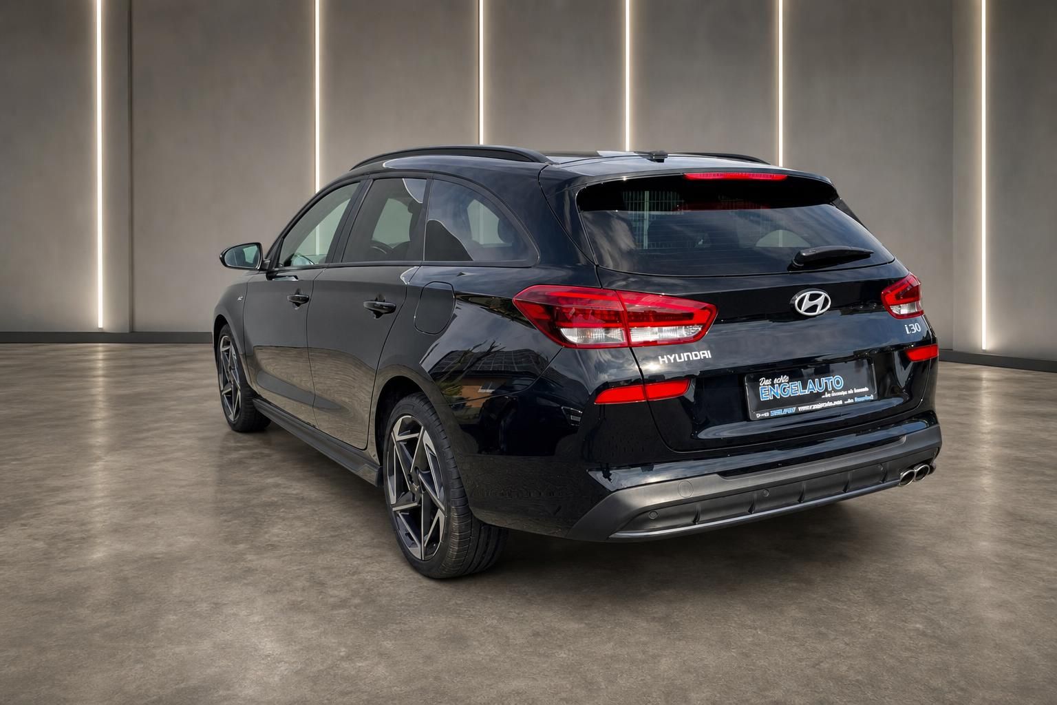 Hyundai i30 Kombi in schwarz - Heckansicht mit Alufelgen im modernen Showroom