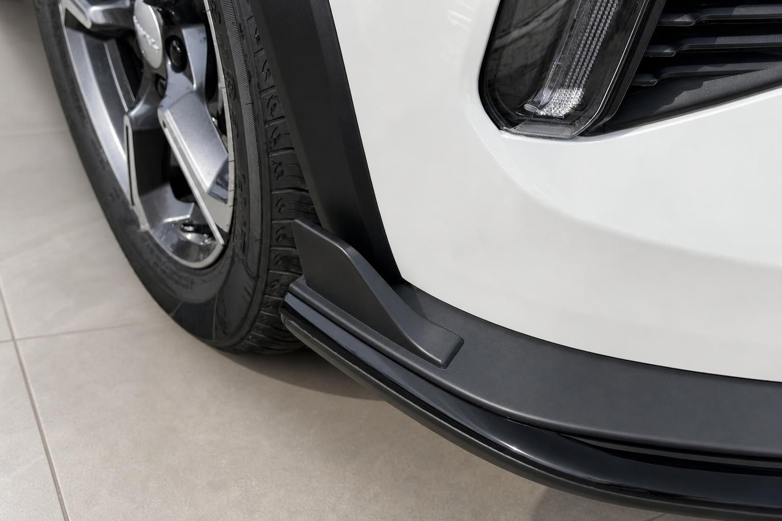Weißes SUV Detailaufnahme Frontstoßstänger mit Frontspoiler und Felge im Autohaus